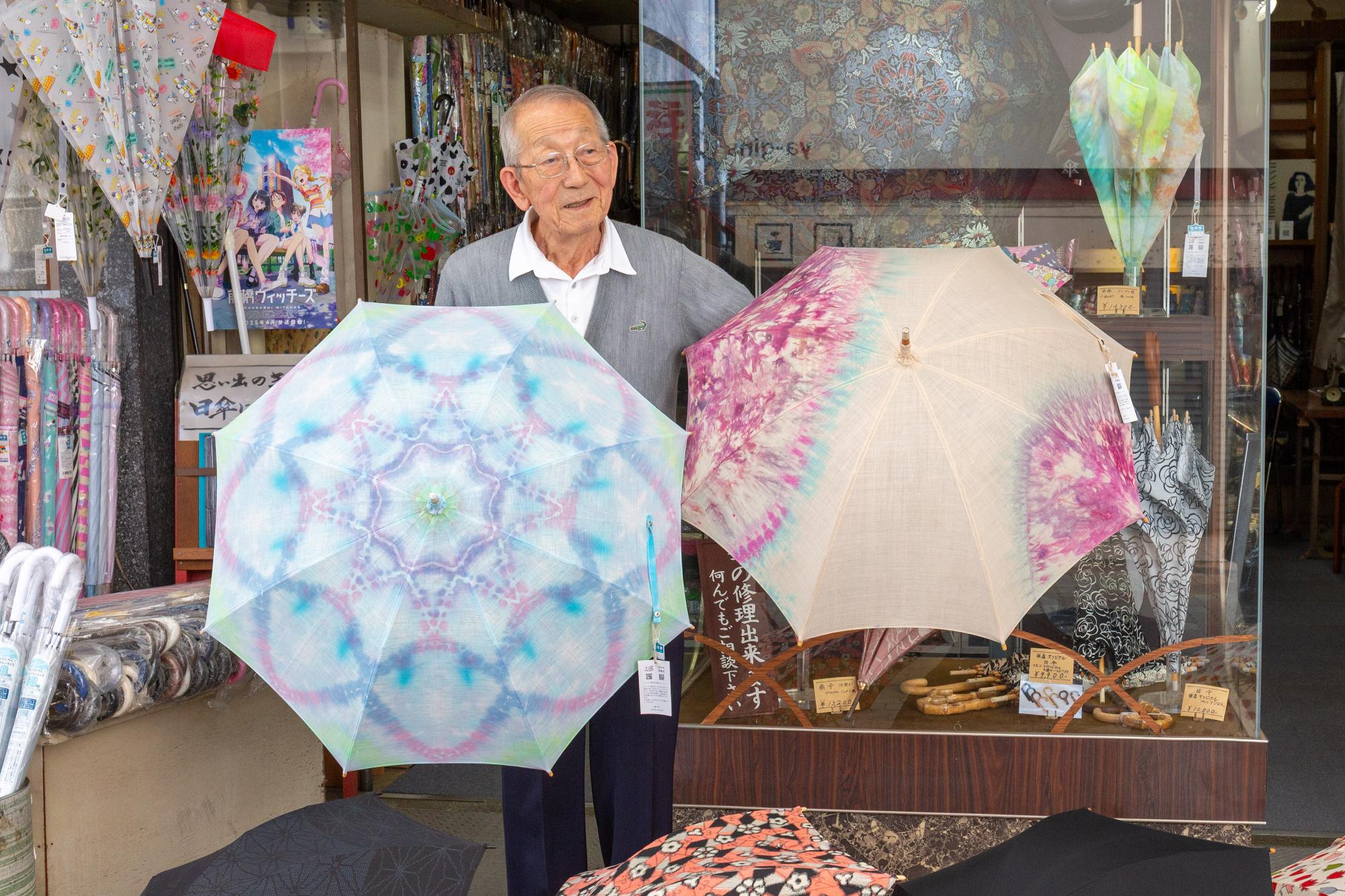 タイダイ染めの日傘を手にする関根健一さん
