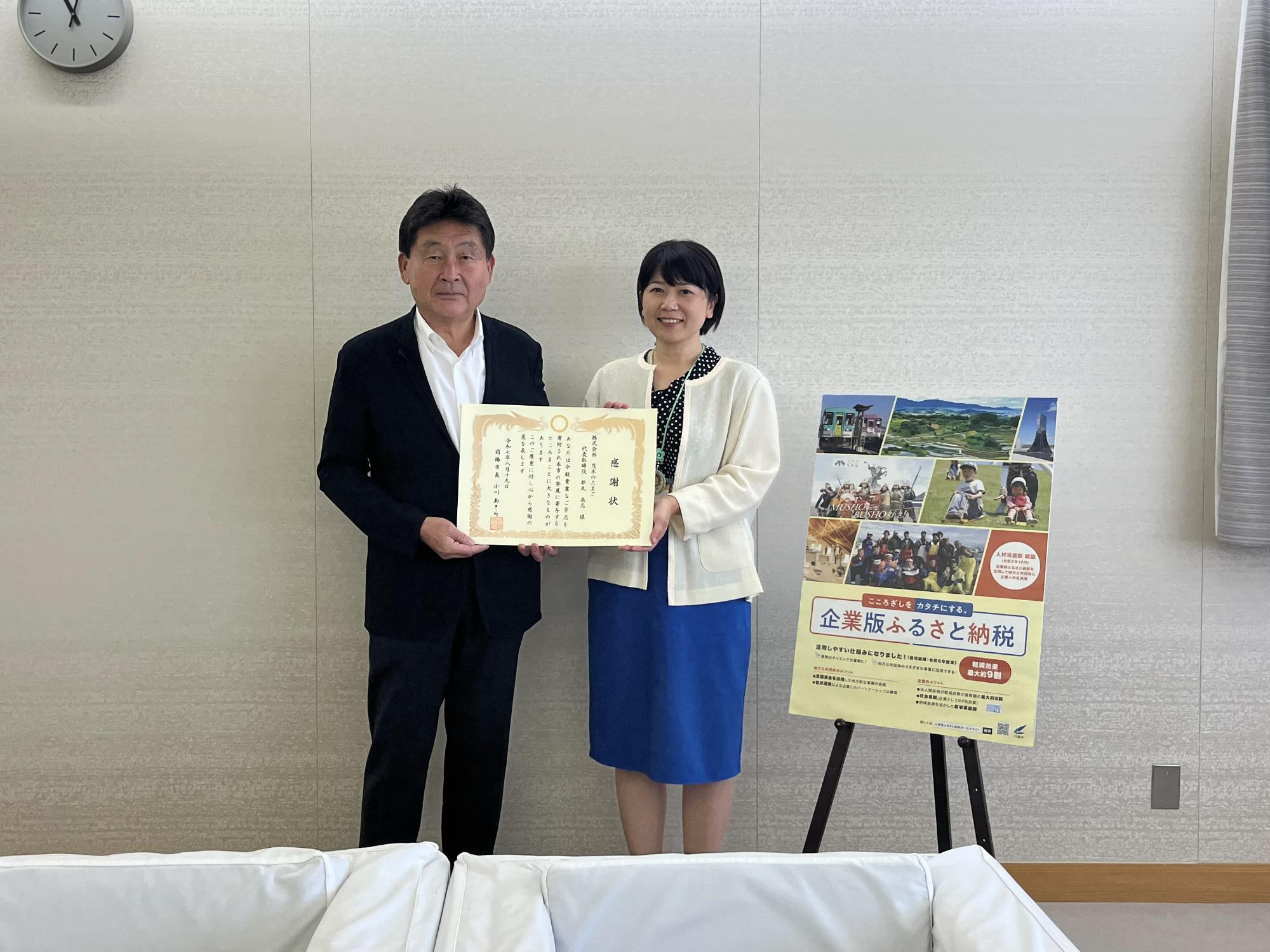 表彰状を手にする市長