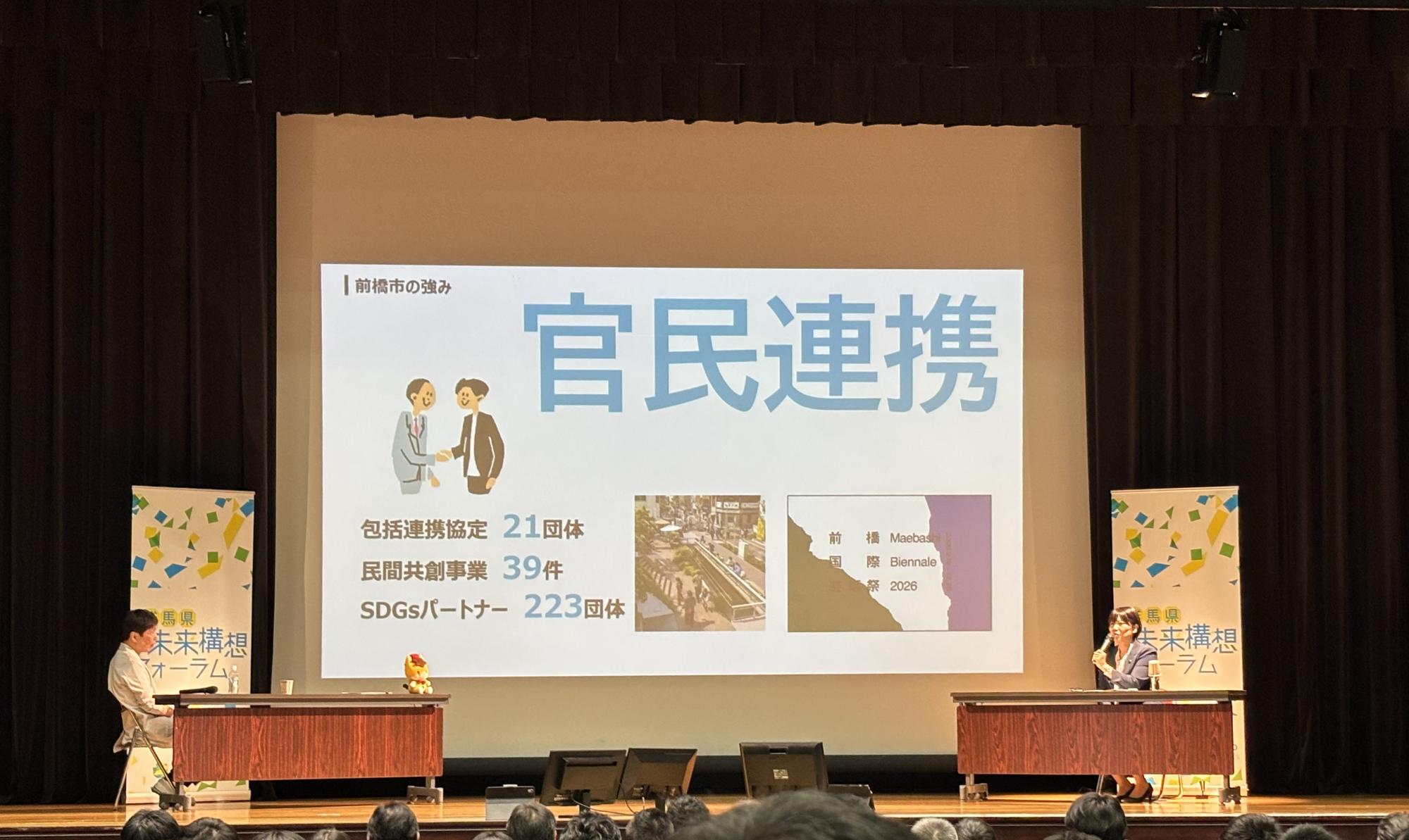 ステージで発言する小川市長と山本知事
