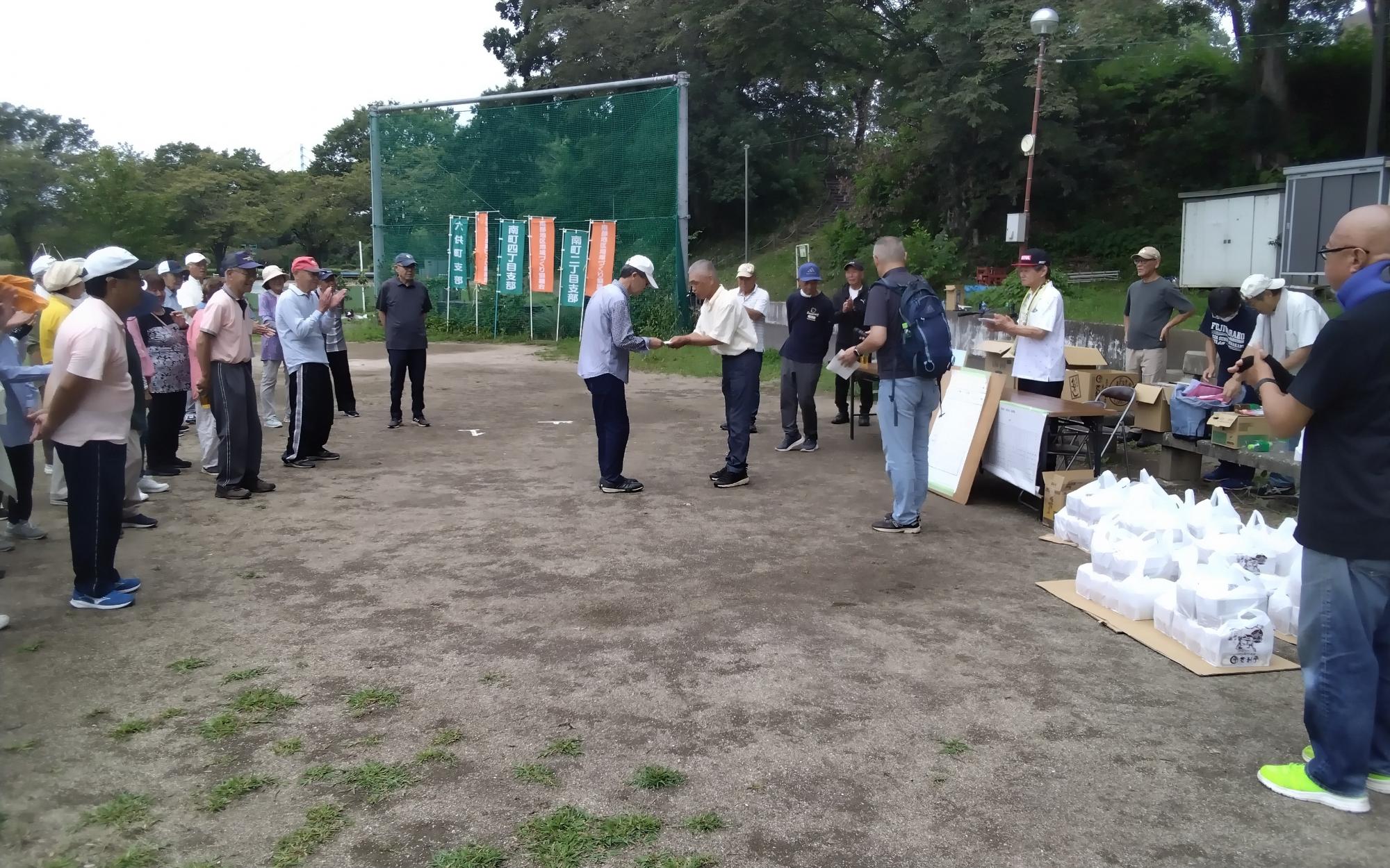 閉会式で優勝チームへ商品を渡す寺本地域づくり協議会長