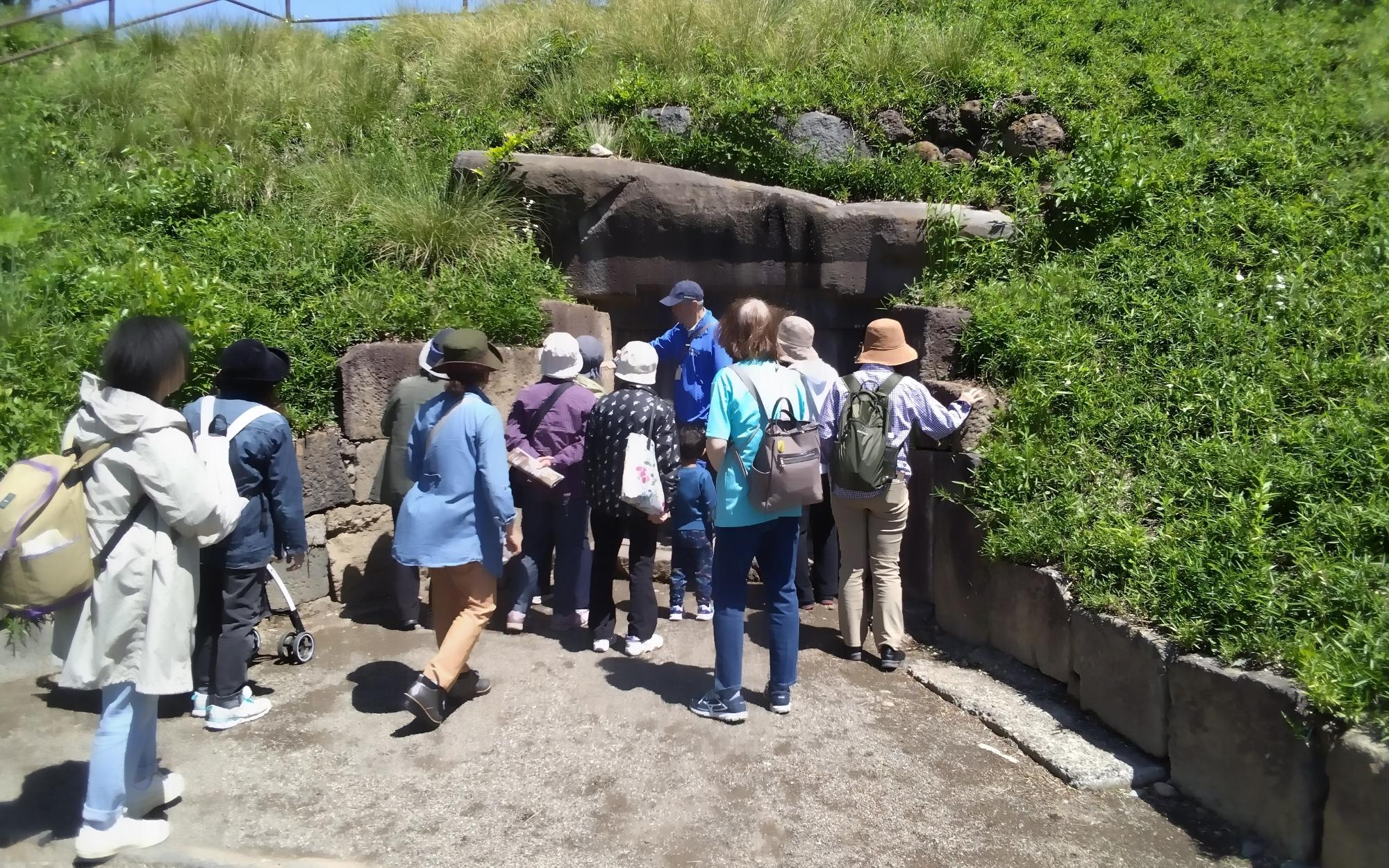 蛇穴山古墳石室前でガイドから説明を受ける参加者