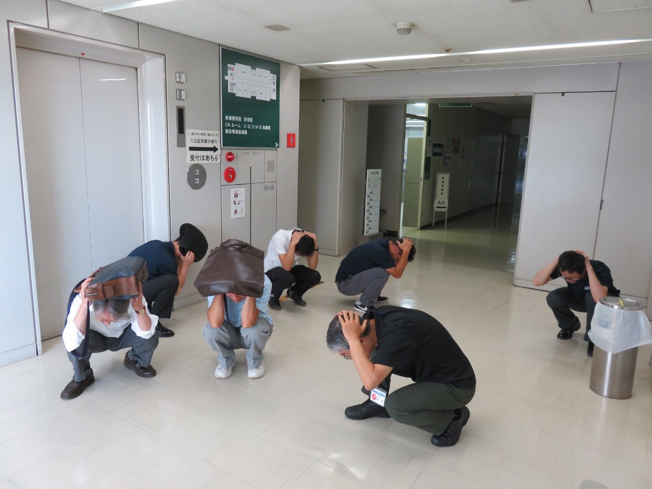 画像:隠れるところが無い場合、カバンや手で頭を守っている写真です。