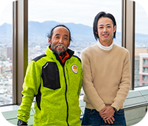 移住コンシェルジュ2名の写真 窓際に立ち微笑んでいる