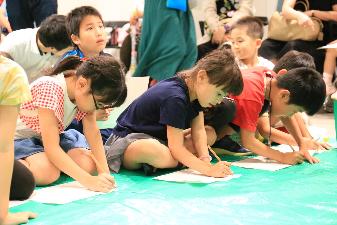 真剣な表情で願いを書く子どもたち