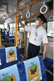 バス内を消毒するバス運転手の写真