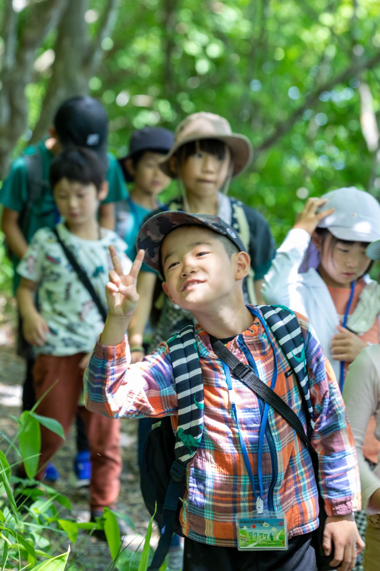 大沼の遊歩道でピースをする子ども