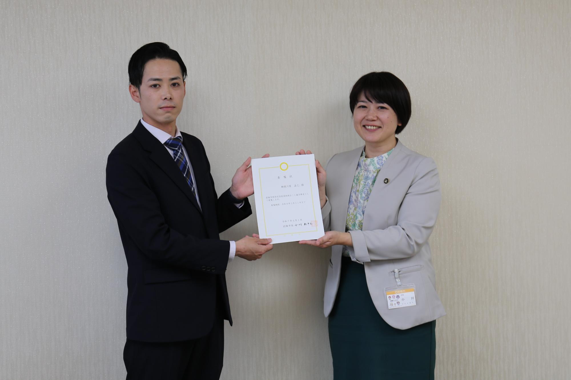委嘱状を手にする市長と地域おこし協力隊員