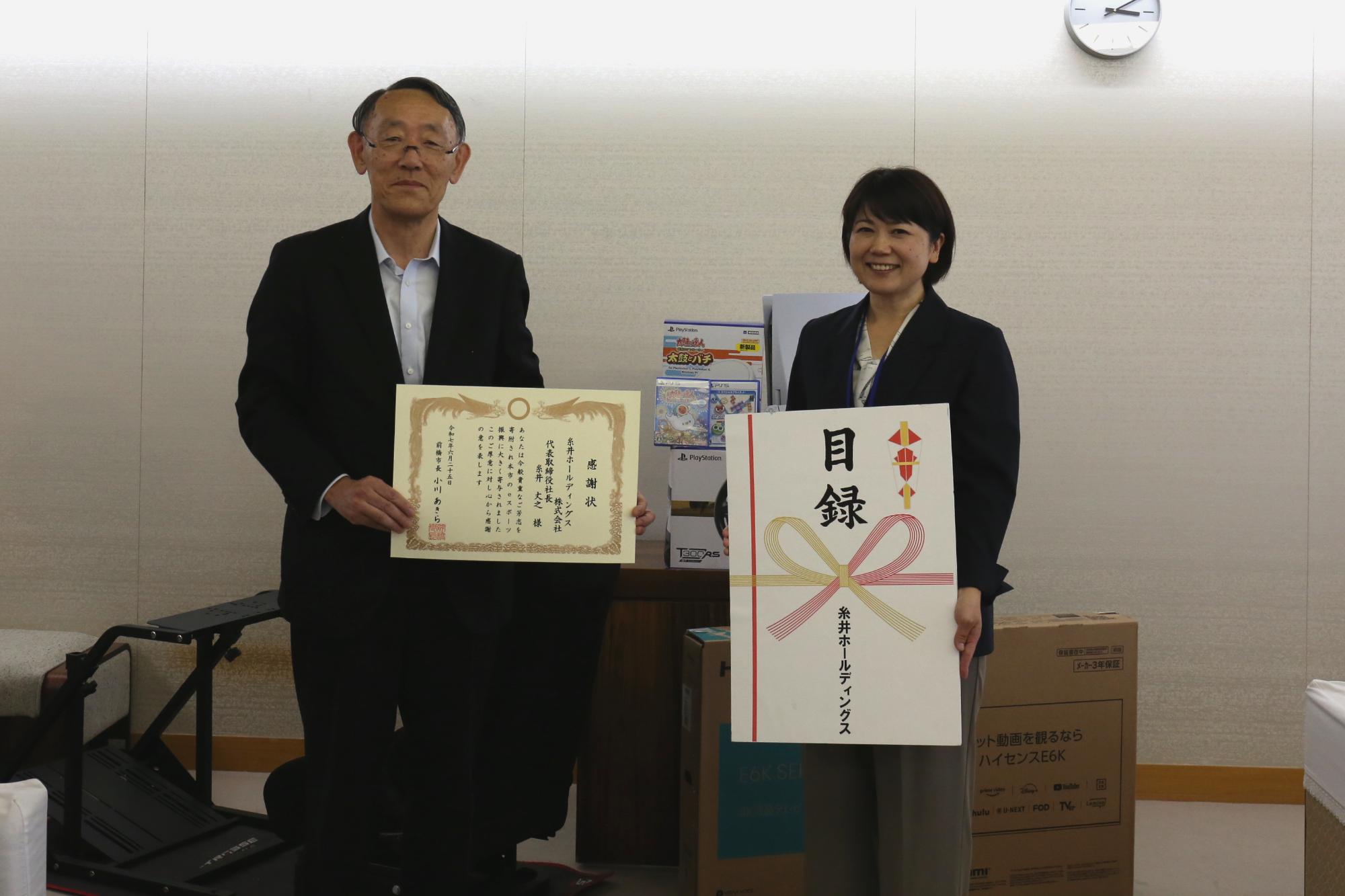 感謝状を持つ糸井代表取締役社長と目録を持つ市長