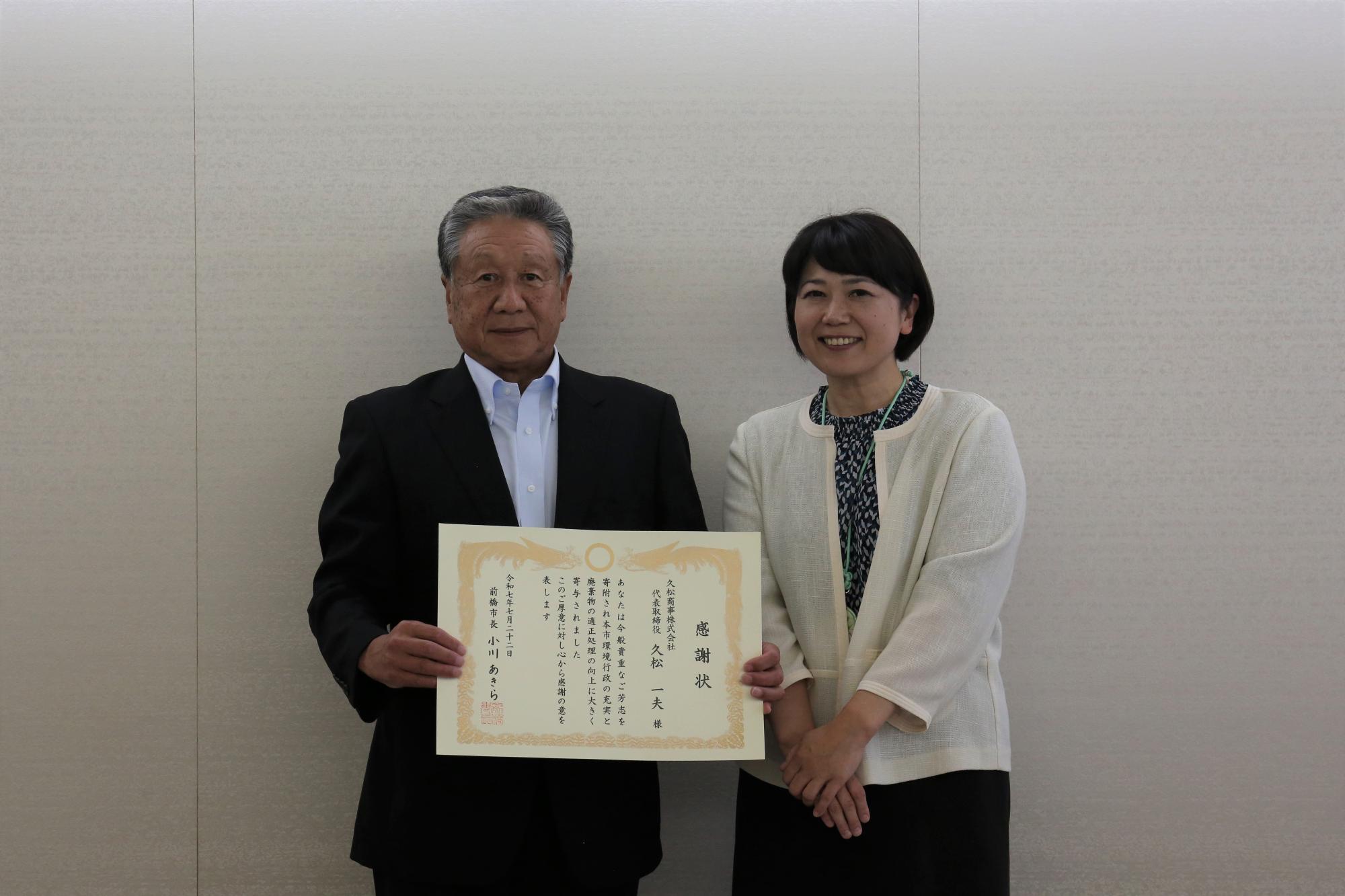 感謝状を持つ久松商事久松社長と市長
