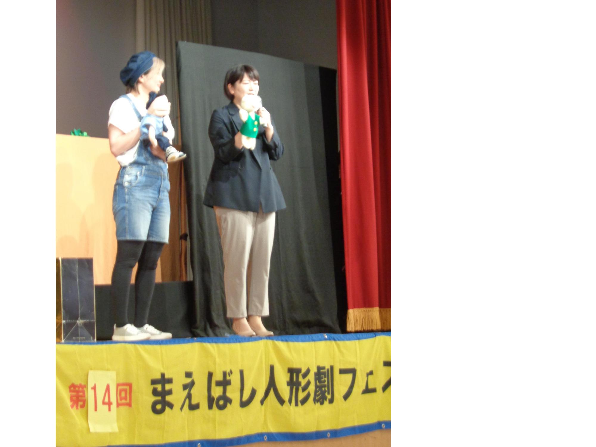 人形を手にはめて登壇する市長