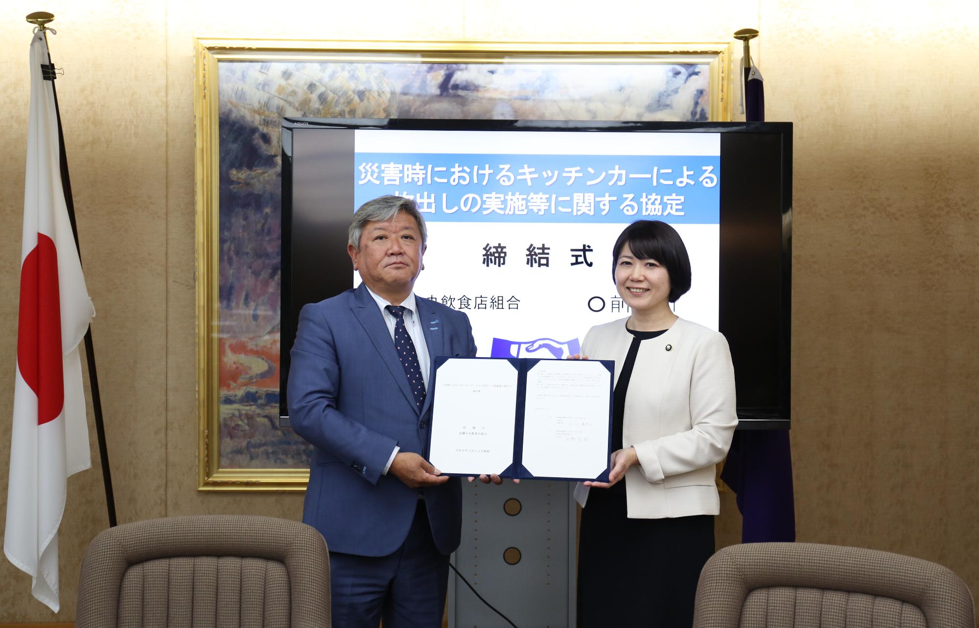 協定書を手にする小川市長と飲食店組合代表