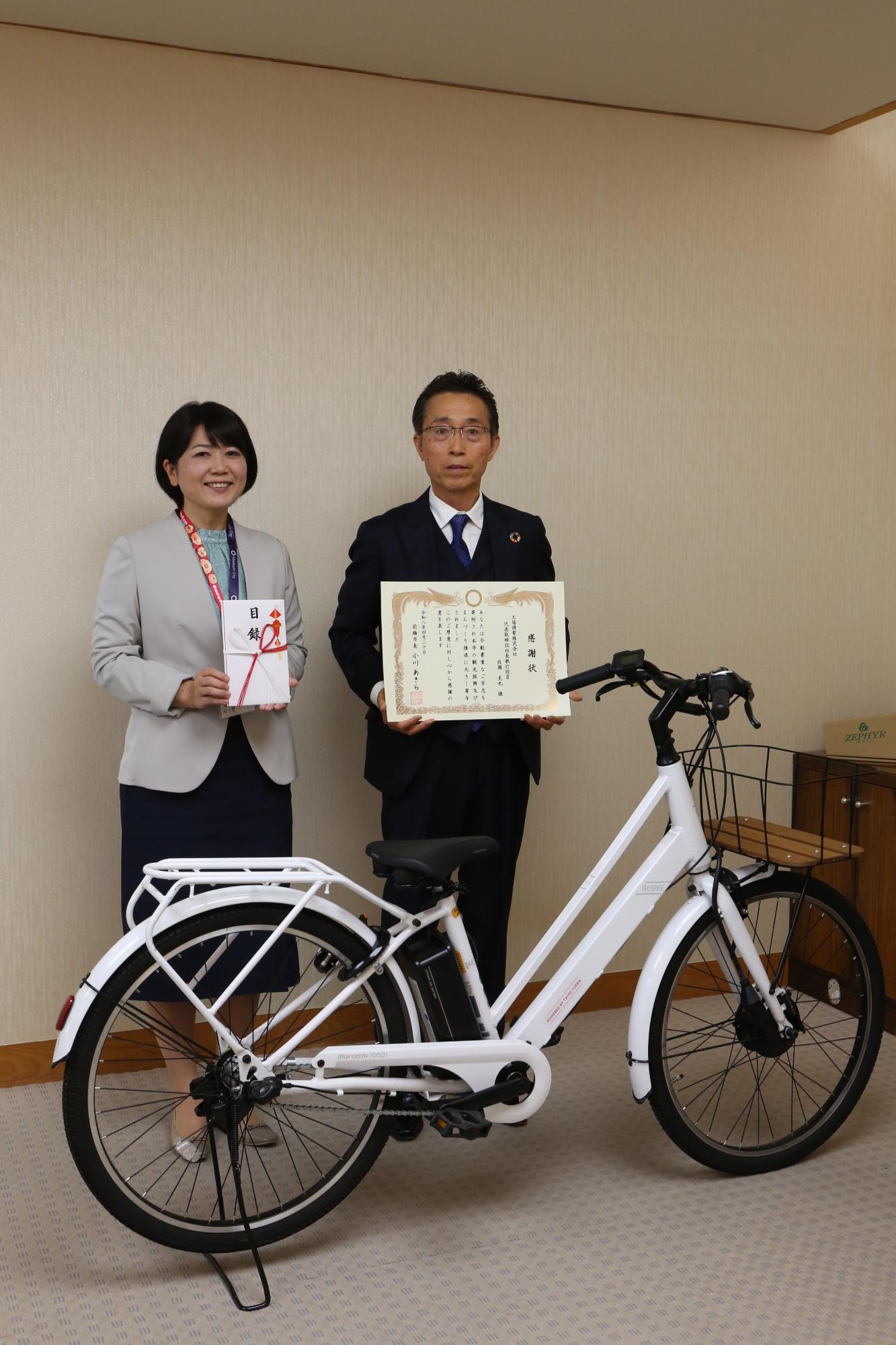 自転車の後ろに並ぶ太陽誘電関係者と小川市長