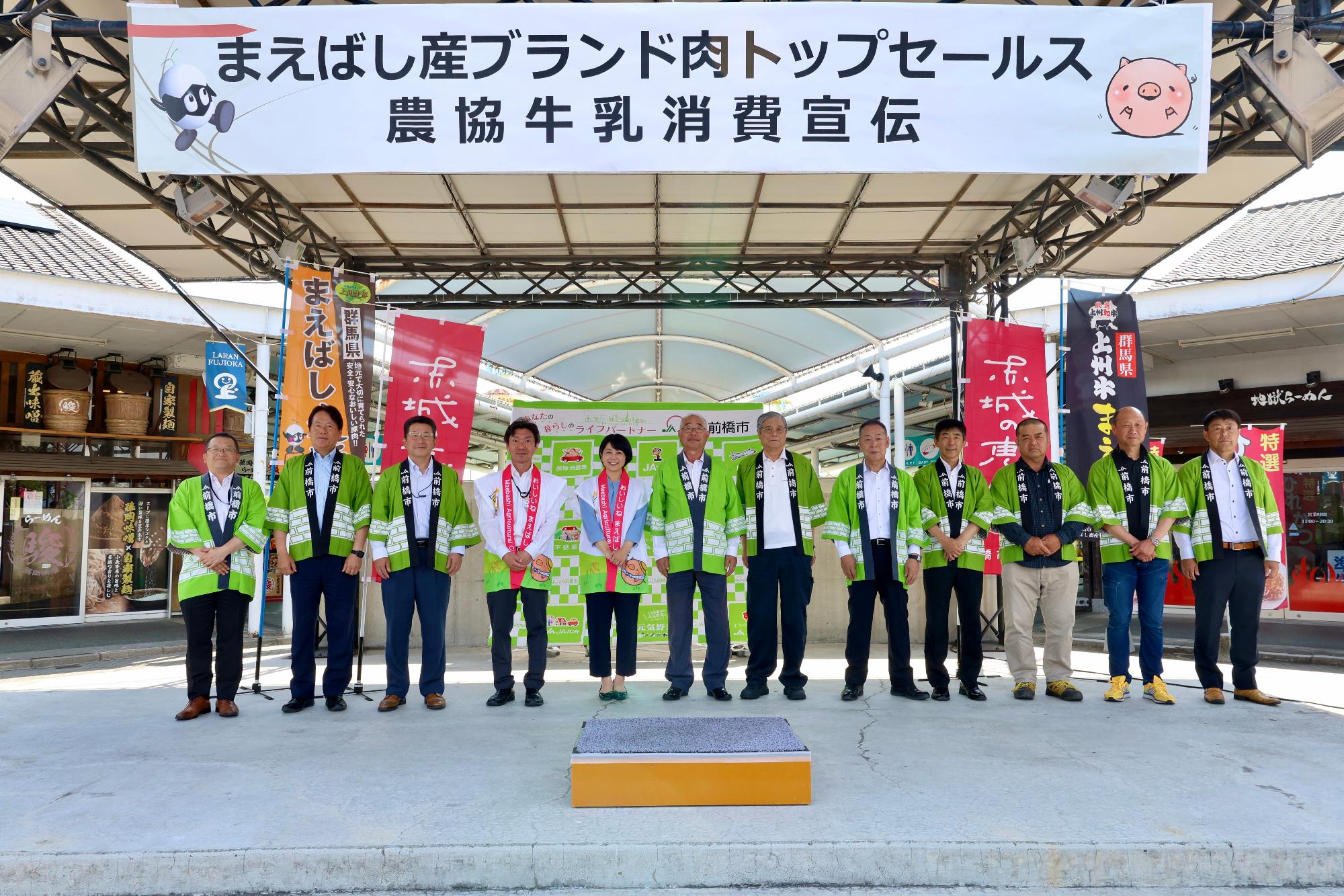 ステージで記念撮影する関係者と小川市長