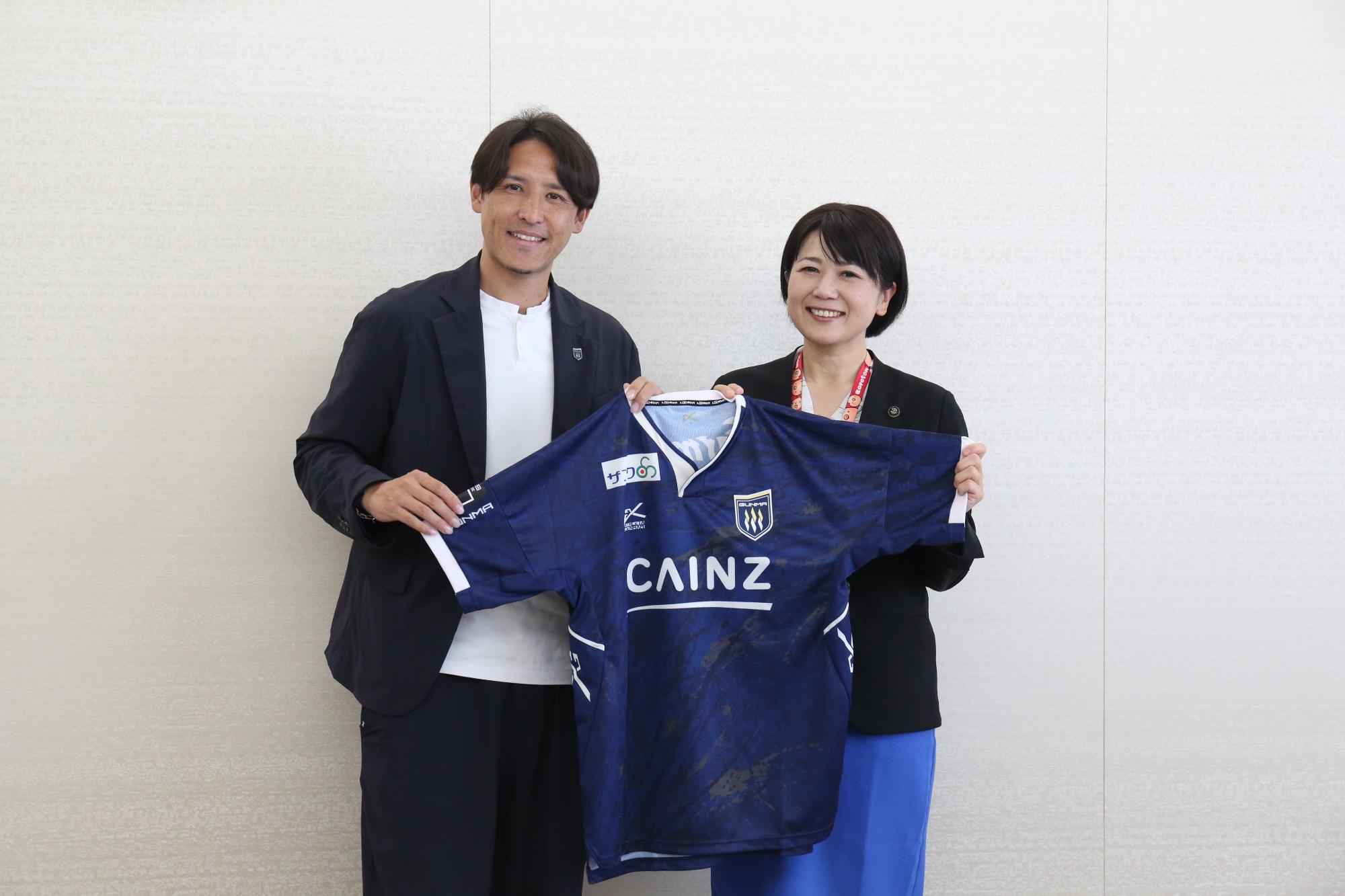 ユニフォームを手にする細貝代表と小川市長