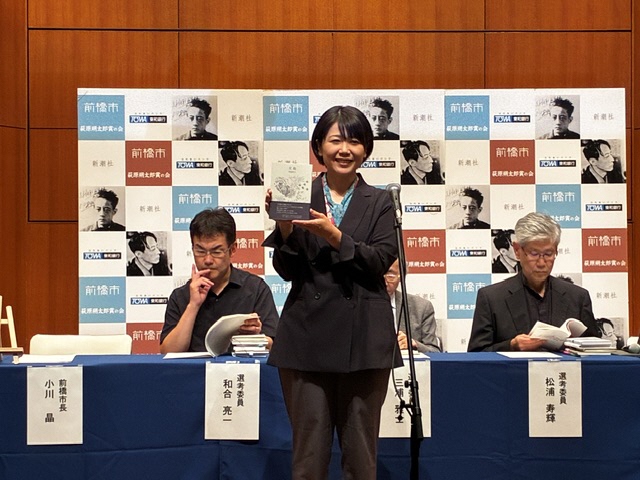 本を持つ小川市長