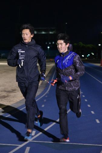 王山運動場でガイドランナーと走る唐澤さんの写真