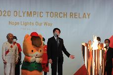 聖火が灯るトーチの前で挨拶する市長の写真
