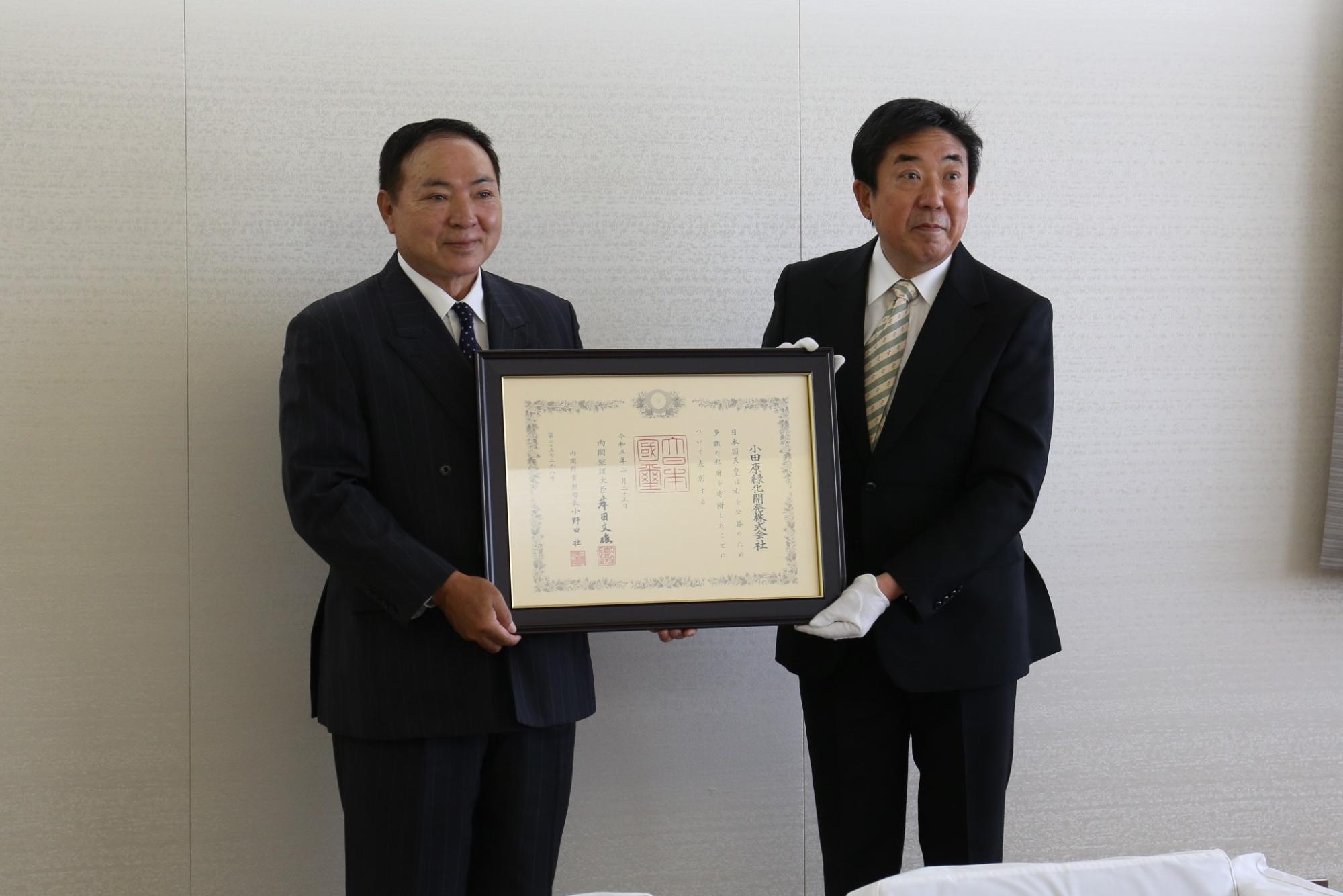 賞状を持つ山本市長と小田原緑化開発の小田原代表取締役
