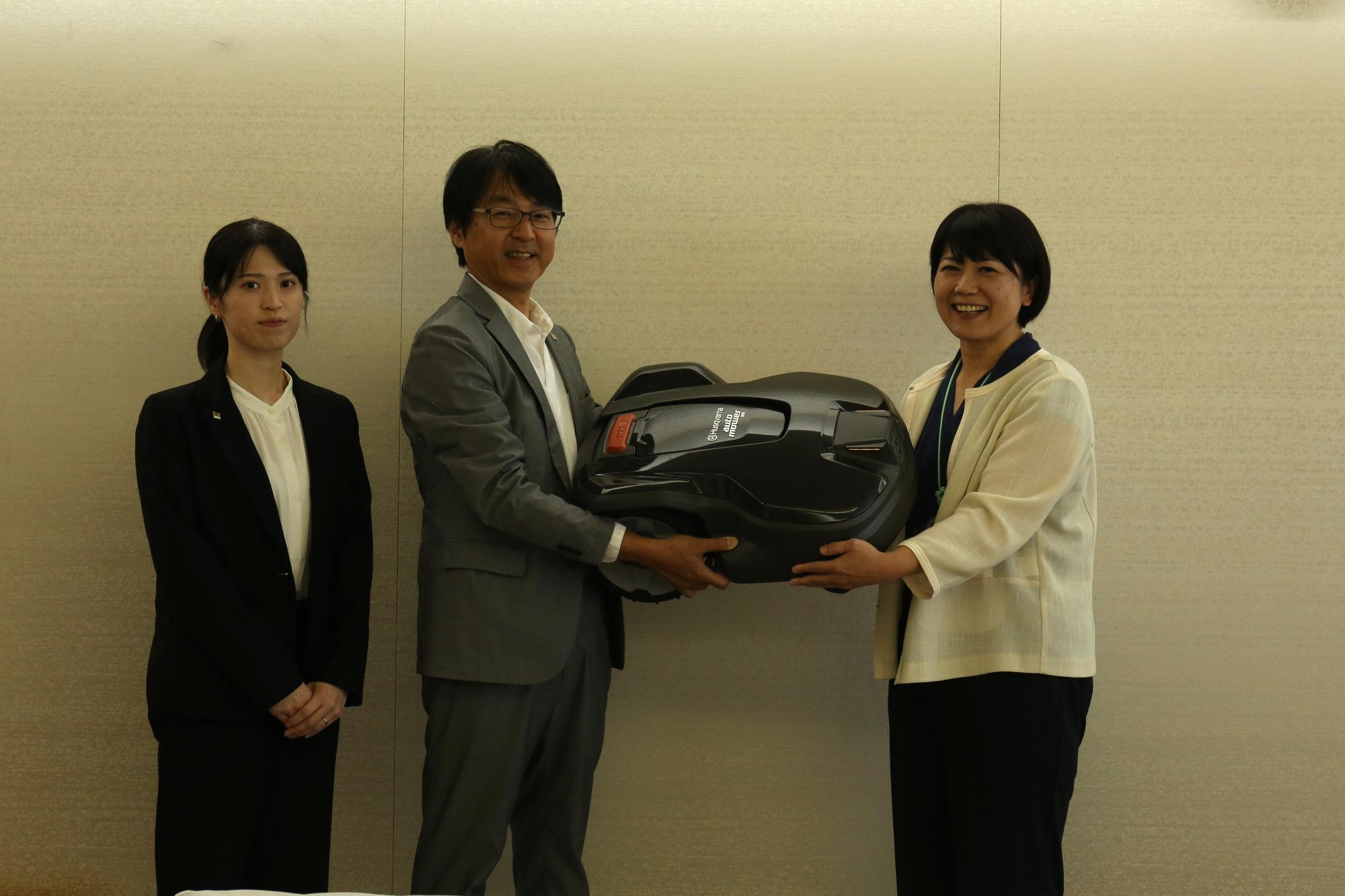 芝刈り機を受け取る市長