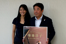 前橋市出身ピアニスト・菊池洋子さんの表敬訪問の写真です。左に菊池さん、右に市長が並んでいて、市長が菊池さんの出演するコンサートのポスターを持っています。