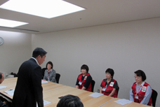 北海道胆振東部地震被災地への派遣職員激励会の写真です。会議室に派遣職員とその他の職員が集合しています。派遣される職員は、赤いベストを着用しています。