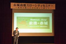 前橋・赤城南麓スローシティセミナーで、市長がステージ上で講演している写真です。