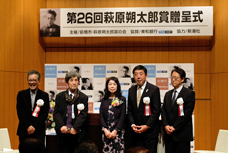 第26回萩原朔太郎賞贈呈式で、市長と受賞者の中本さんを含めた5人がステージに並んでいる写真です。