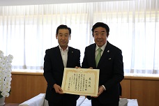前橋市功労者表彰で鈴木俊司市議会議員と表彰状を渡している市長の写真