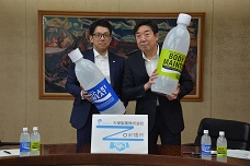 大塚製薬株式会社との包括協定締結式で大きなペットボトルの模型を持っている市長と代表の写真