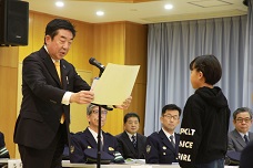 交通安全コンクール表彰式で表彰状を手渡している市長の写真