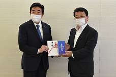 綜合プランニングから寄附されたマスクを受け取る山本市長の写真