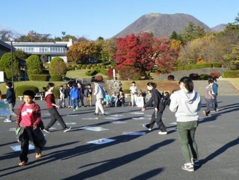 広場で画用紙ほどの大きい富士見カルタをする子供たち