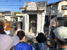 11月3日朝日町二丁目自治会長の庚申社宮石の説明を聞いている写真