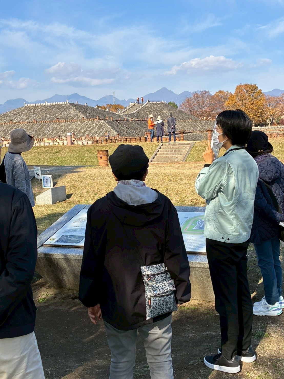 ガイドから古墳の説明を受ける参加者
