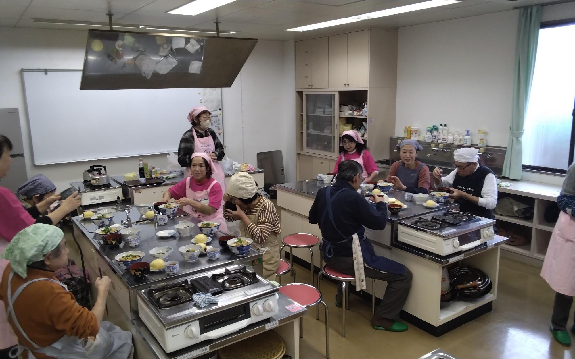 完成した料理を試食する様子