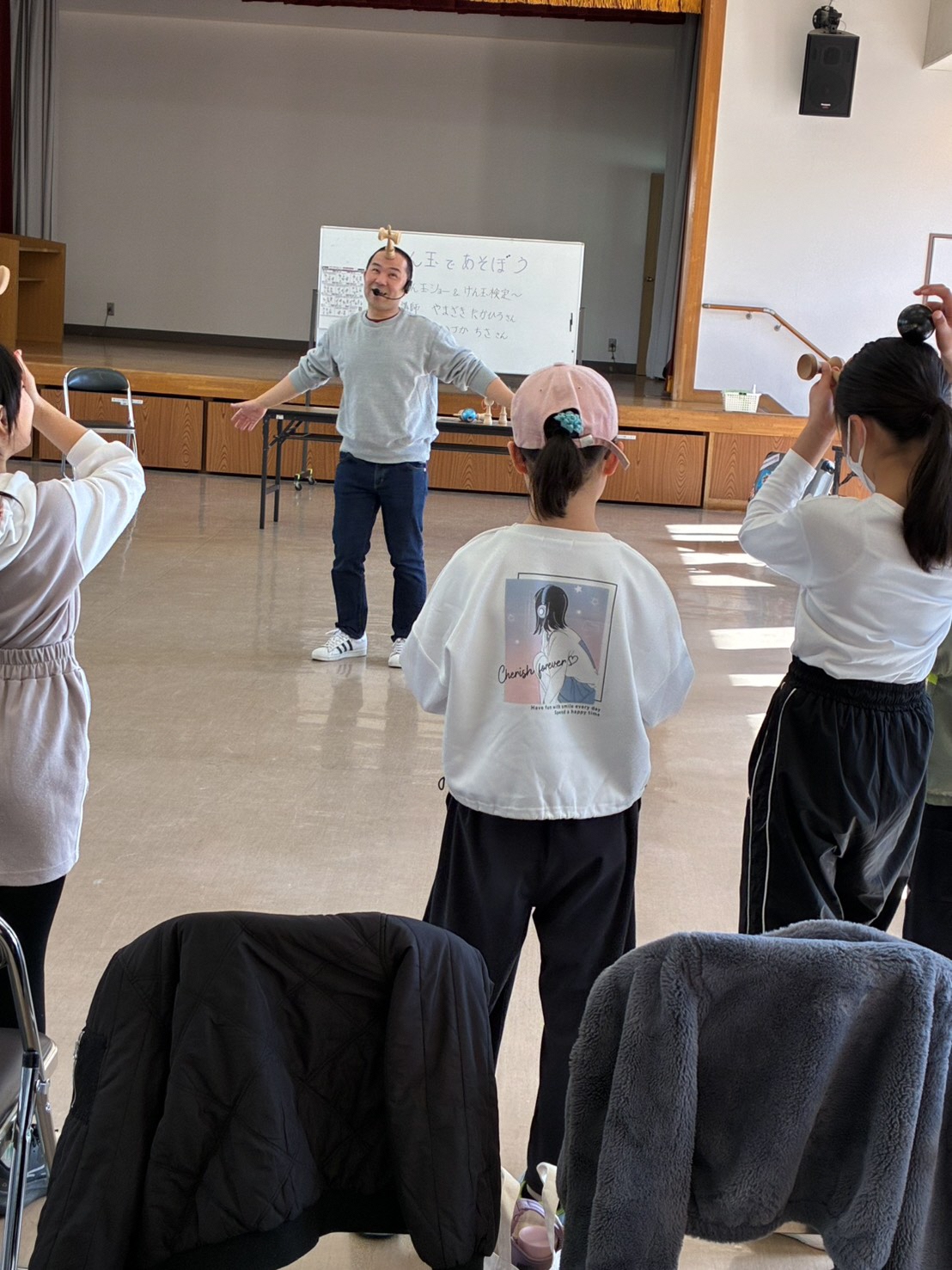 講師と一緒にけん玉を使って遊ぶ様子