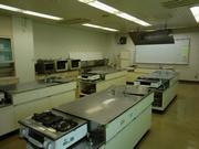 調理実習室の画像。コンロがついている調理台が5台ある。